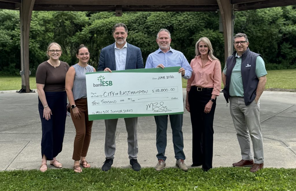 A group shot of bank employees and the mayor holding a check donation to the town. 